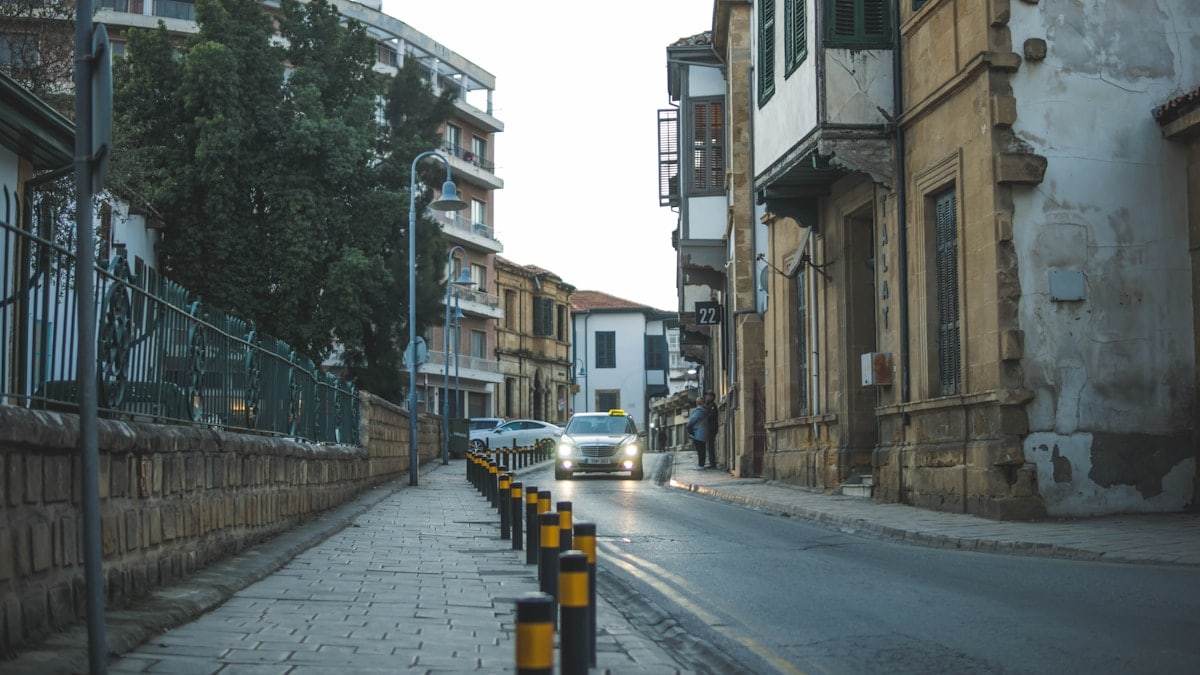 a car driving down a street next to tall buildings
